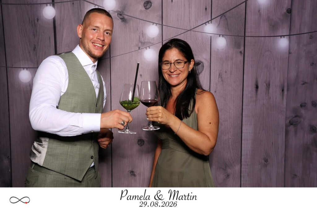 Gäste stossen in der Fotobox mit Cocktails an