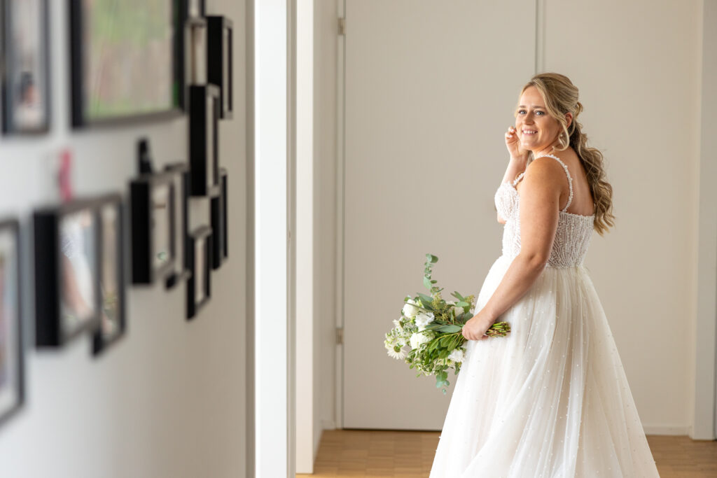 Braut im Hochzeitskleid vor dem Spiegel